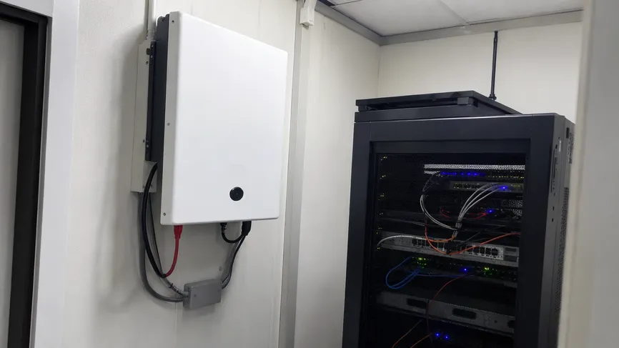 Wall mounted battery installed in a small commercial server room for backup power