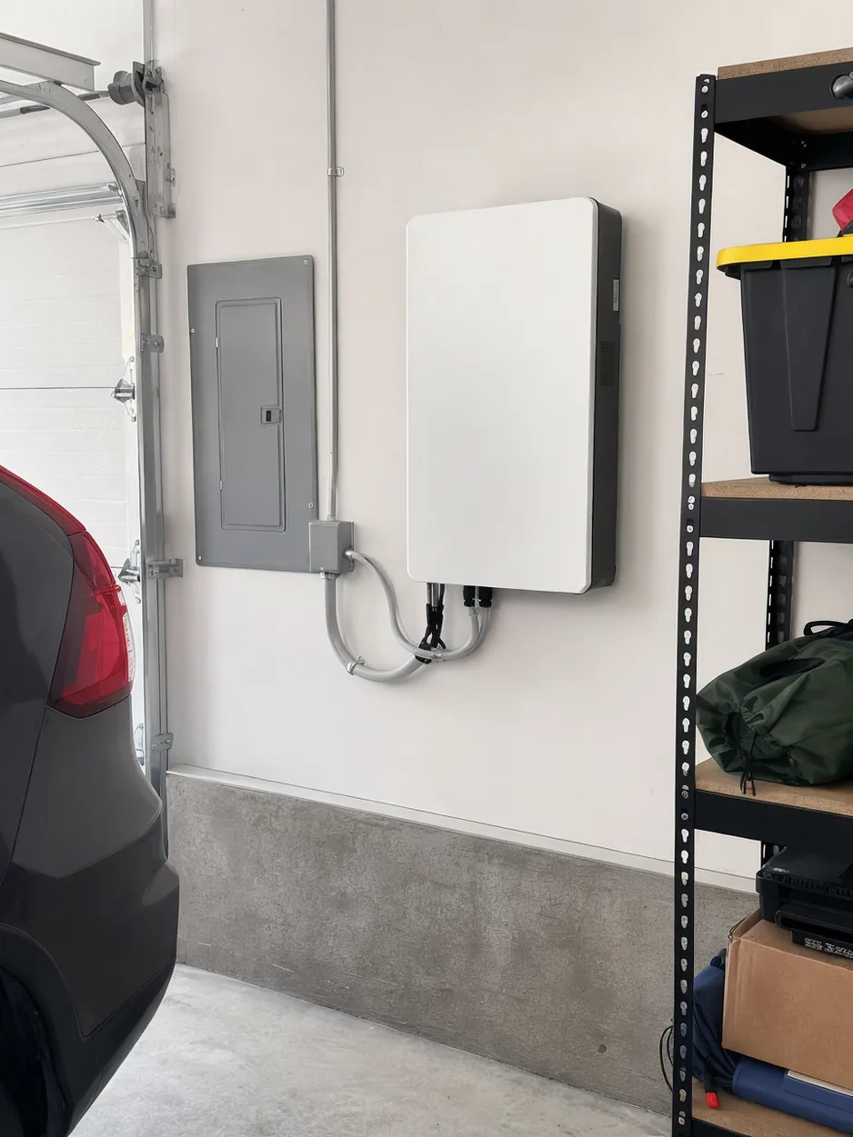 JXSOL wall mounted lithium battery installed in a residential garage setting