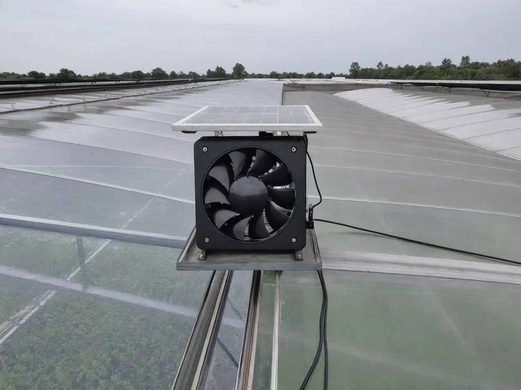 Solar exhaust fan installed on greenhouse roof for agricultural ventilation