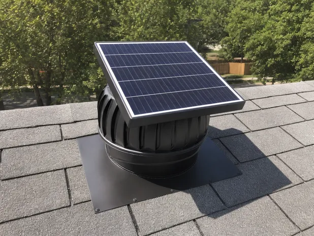 Solar exhaust fan installed on attic roof for daytime heat extraction