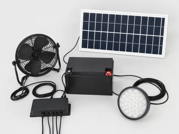 Solar fan with LED light kit components laid out — panel, battery, fan motor, LED array, controller