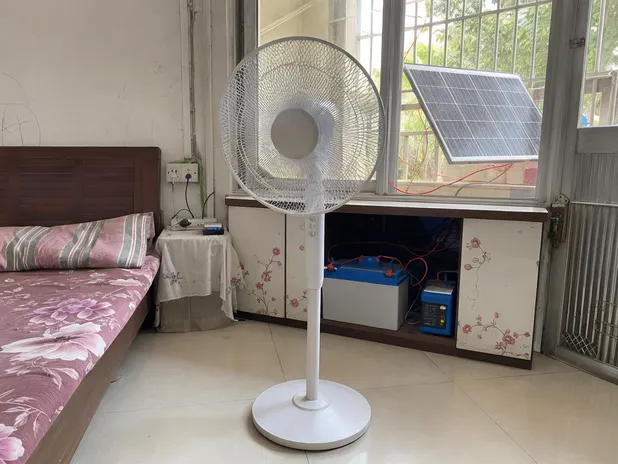 Solar stand fan in off-grid household setting — pedestal format for living room and bedroom use