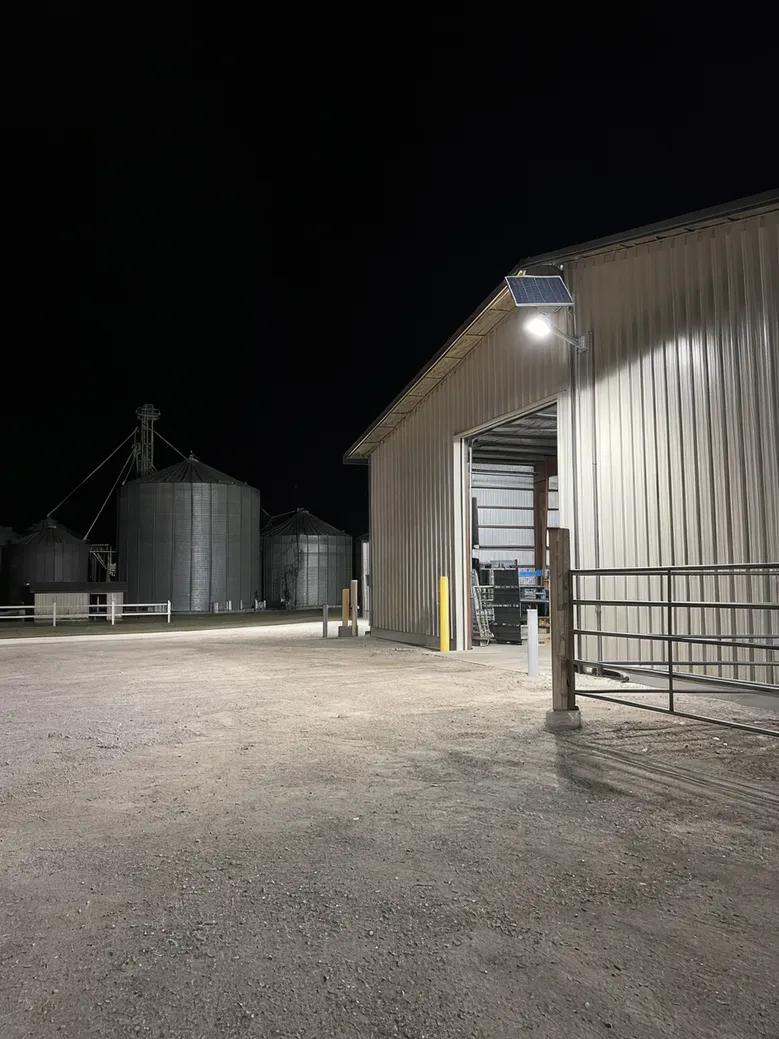 Solar flood light illuminating a large agricultural storage facility at night