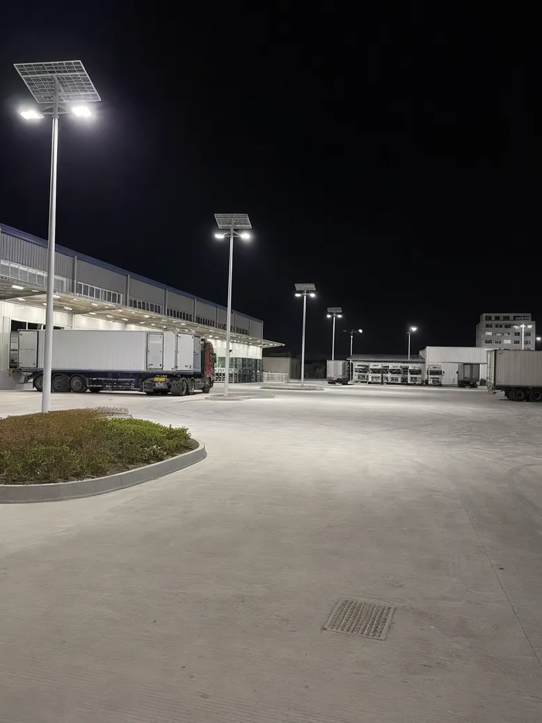 Solar flood lights illuminating a logistics yard with loading docks at night