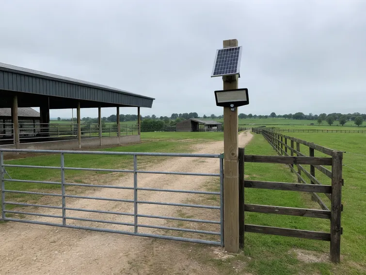 PIR solar security light mounted at agricultural property gate approach for off-grid perimeter security