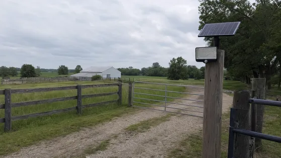 Solar motion sensor security light installed at a farm gate entrance