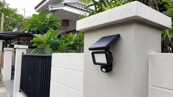 Compact solar motion sensor flood light installed on a residential perimeter wall