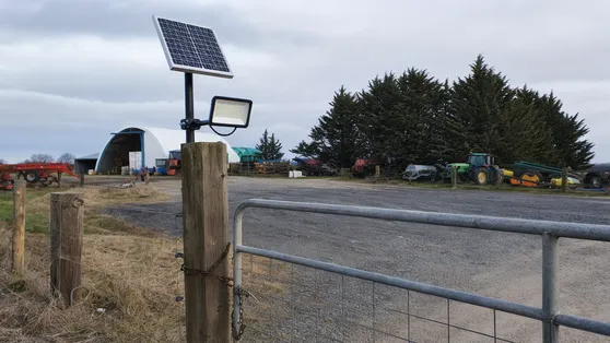 Solar security light on agricultural farm gate and equipment yard entrance