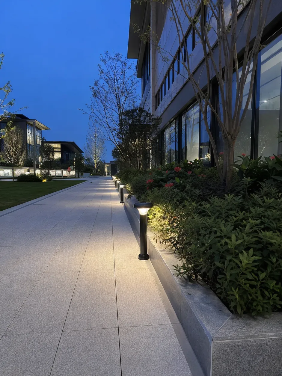 JXSOL solar landscape lighting fixtures installed along a commercial pathway at dusk