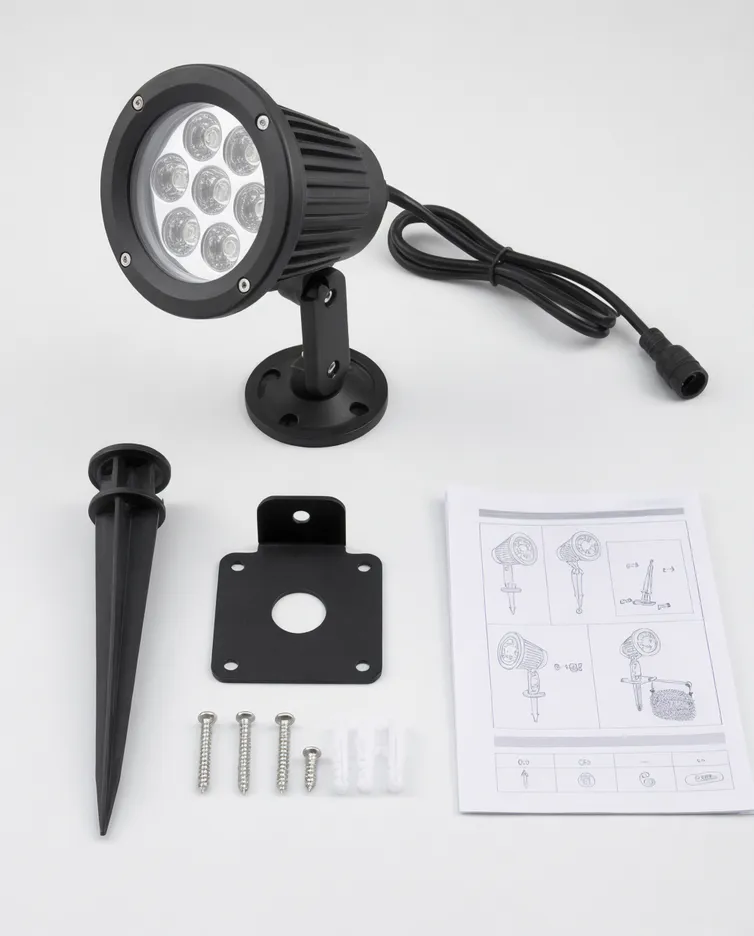 Solar spotlight accessory pack showing stake, bracket, screws, and instruction sheet