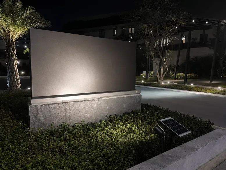 Narrow-beam solar spotlight illuminating a commercial monument sign at night