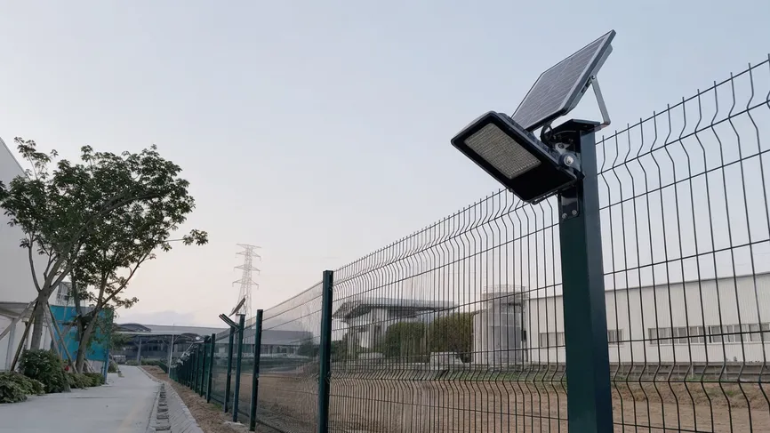 Solar area light mounted on a factory perimeter fence for security illumination