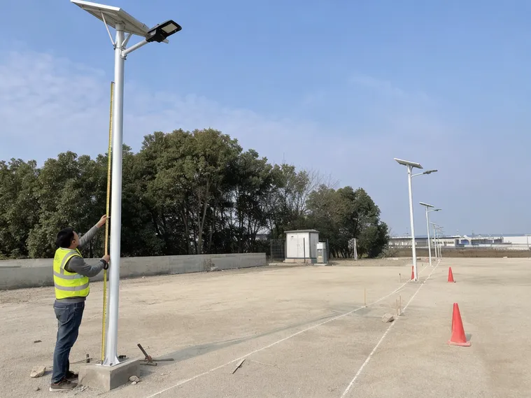 Solar area light installation site showing pole height measurement and spacing layout for correct fixture specification