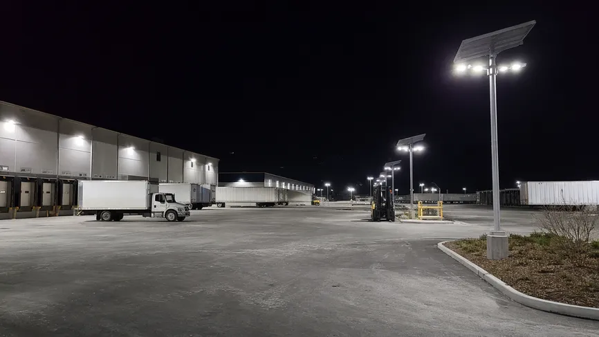 Solar parking lot fixtures lighting a logistics facility and warehouse parking zone at night