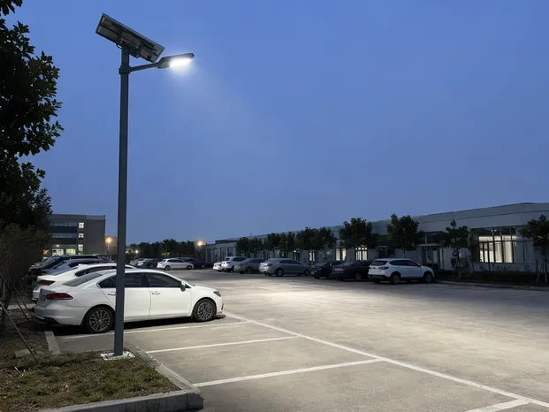 Solar parking lot light fixture mounted on pole in commercial parking environment showing beam coverage pattern