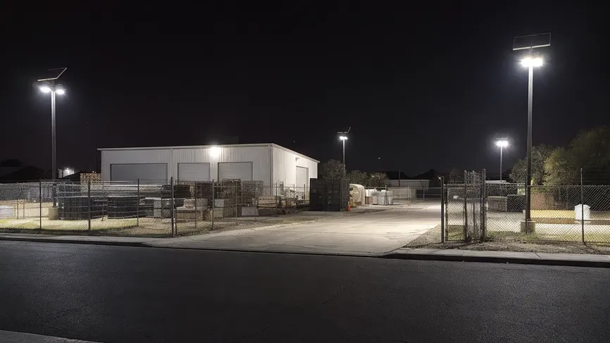 Solar yard lights illuminating a small commercial storage yard perimeter at night