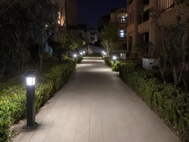 Solar yard lights illuminating a residential compound pathway at night
