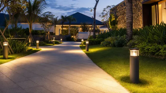 Warm-tone solar bollard lights along a resort entrance path