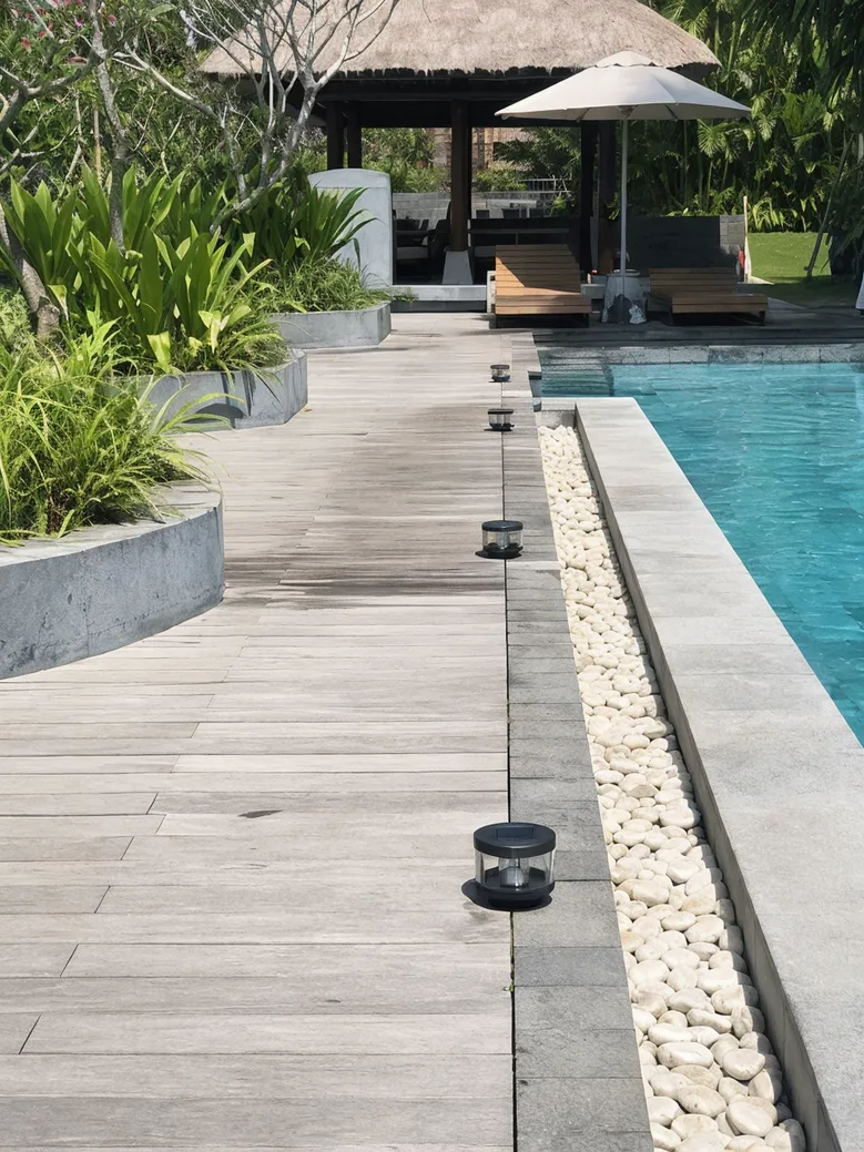 Solar deck lights installed on a resort pool terrace boardwalk
