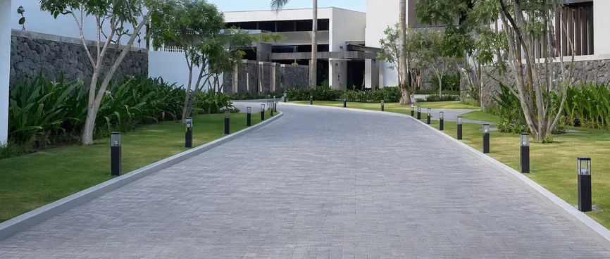 Consistent solar bollard lights along a resort entrance driveway