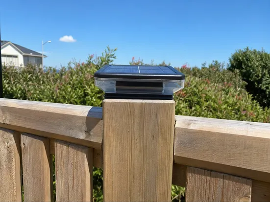Solar fence light fence-top cap mounting on timber post with skyward-facing panel