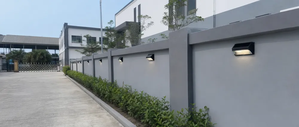 Solar fence lights installed along a perimeter boundary wall in a commercial compound development