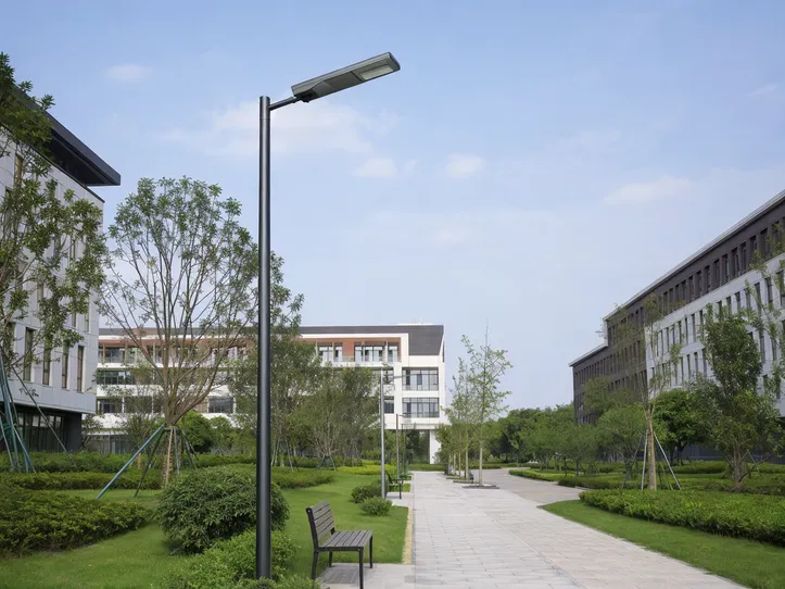 All-in-one solar street light installed along a university campus pathway with landscaped surroundings