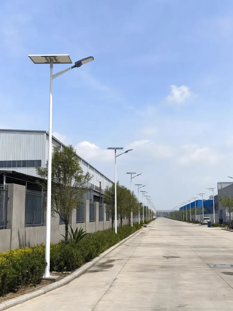 Solar road lights installed along a straight industrial estate access road with consistent pole spacing