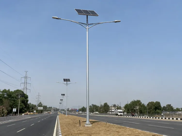 Tall 10-12m solar street lighting pole with double arm configuration on a multi-lane arterial road