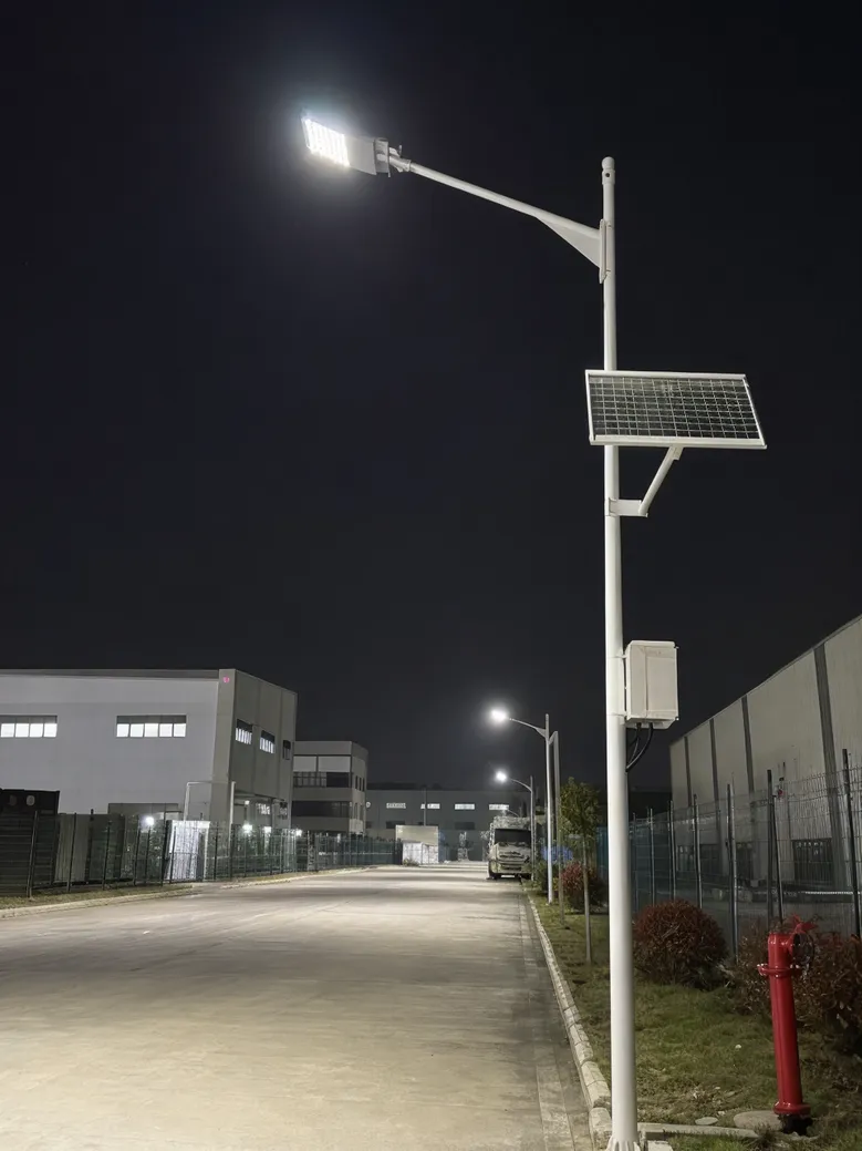 High-output split solar street light illuminating industrial park access road at night