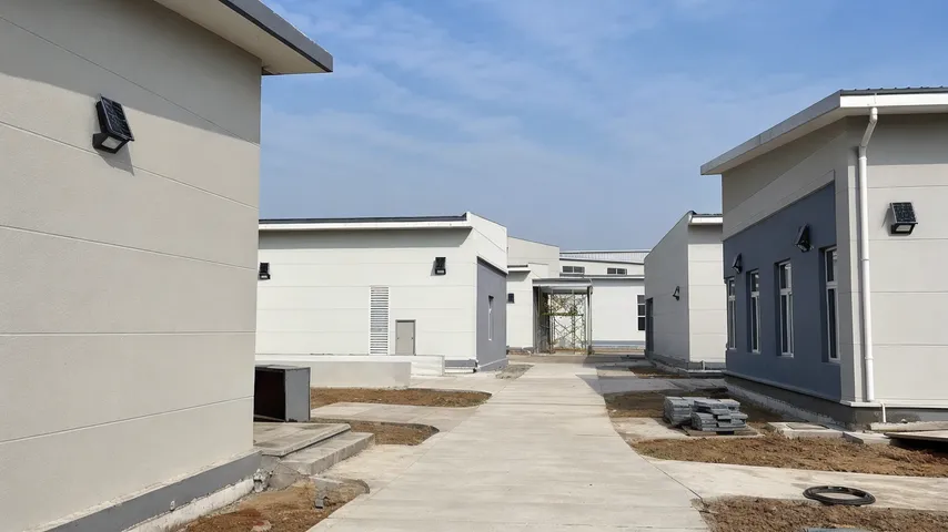 Multi-building project site showing consistent solar wall light installations across different wall orientations