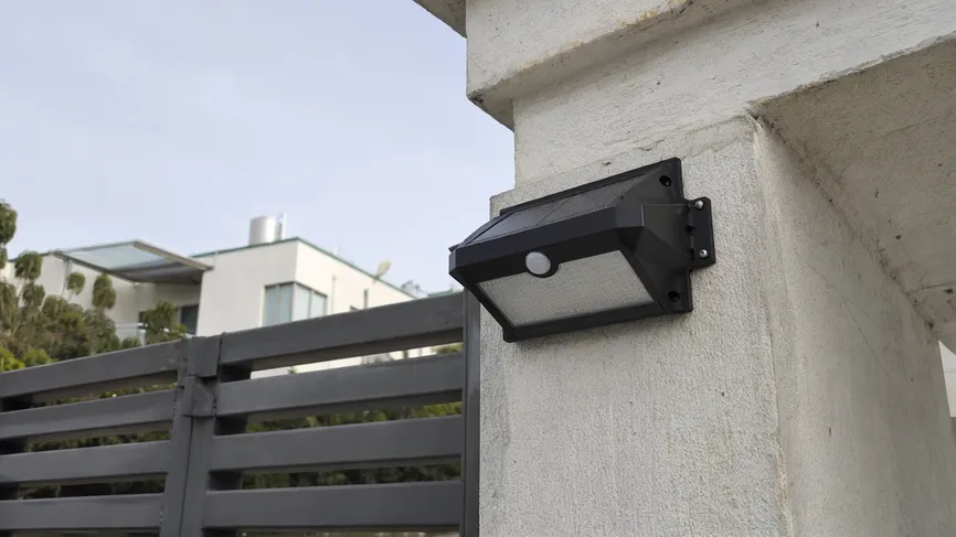 PIR motion sensor solar wall light installed on a perimeter wall for security lighting