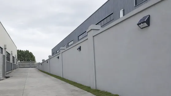 Motion sensor solar wall lights on commercial perimeter wall for security lighting