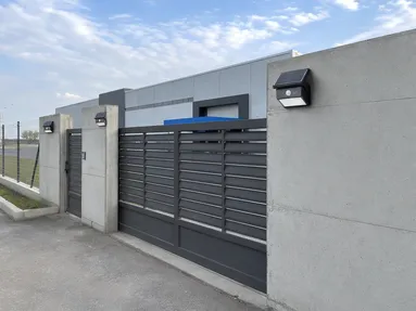 Solar wall lights along commercial property perimeter wall and boundary gate