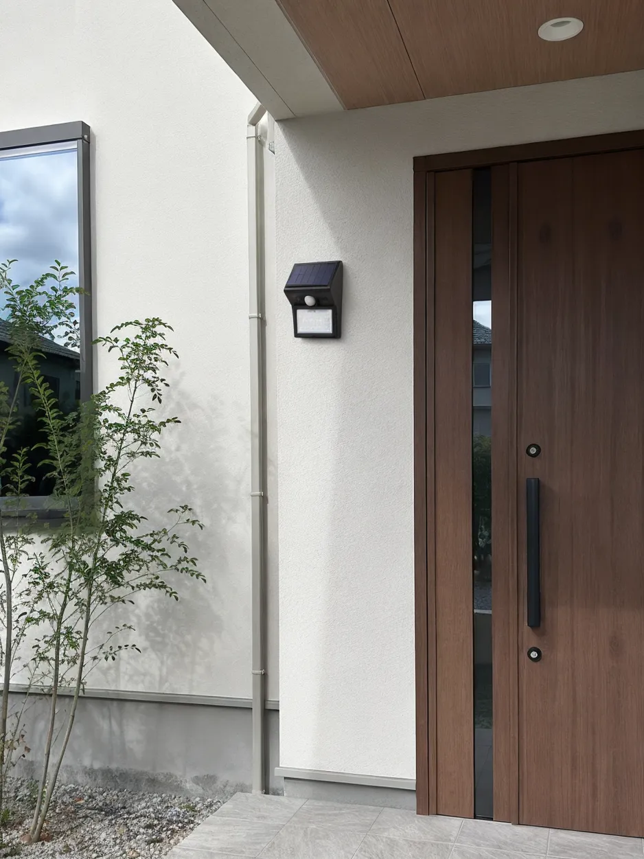 JXSOL compact solar porch light installed on residential entrance wall