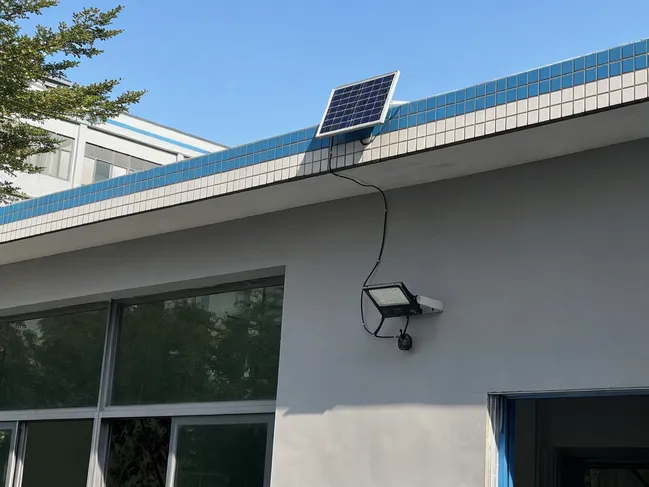North-facing building wall in shadow with solar panel mounted on sunlit roof edge above