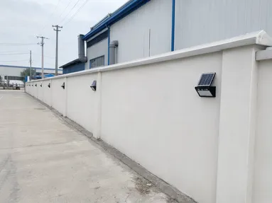 Solar wall lights along an industrial facility perimeter boundary wall