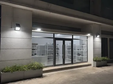 Solar wall lights illuminating a retail storefront entrance at night