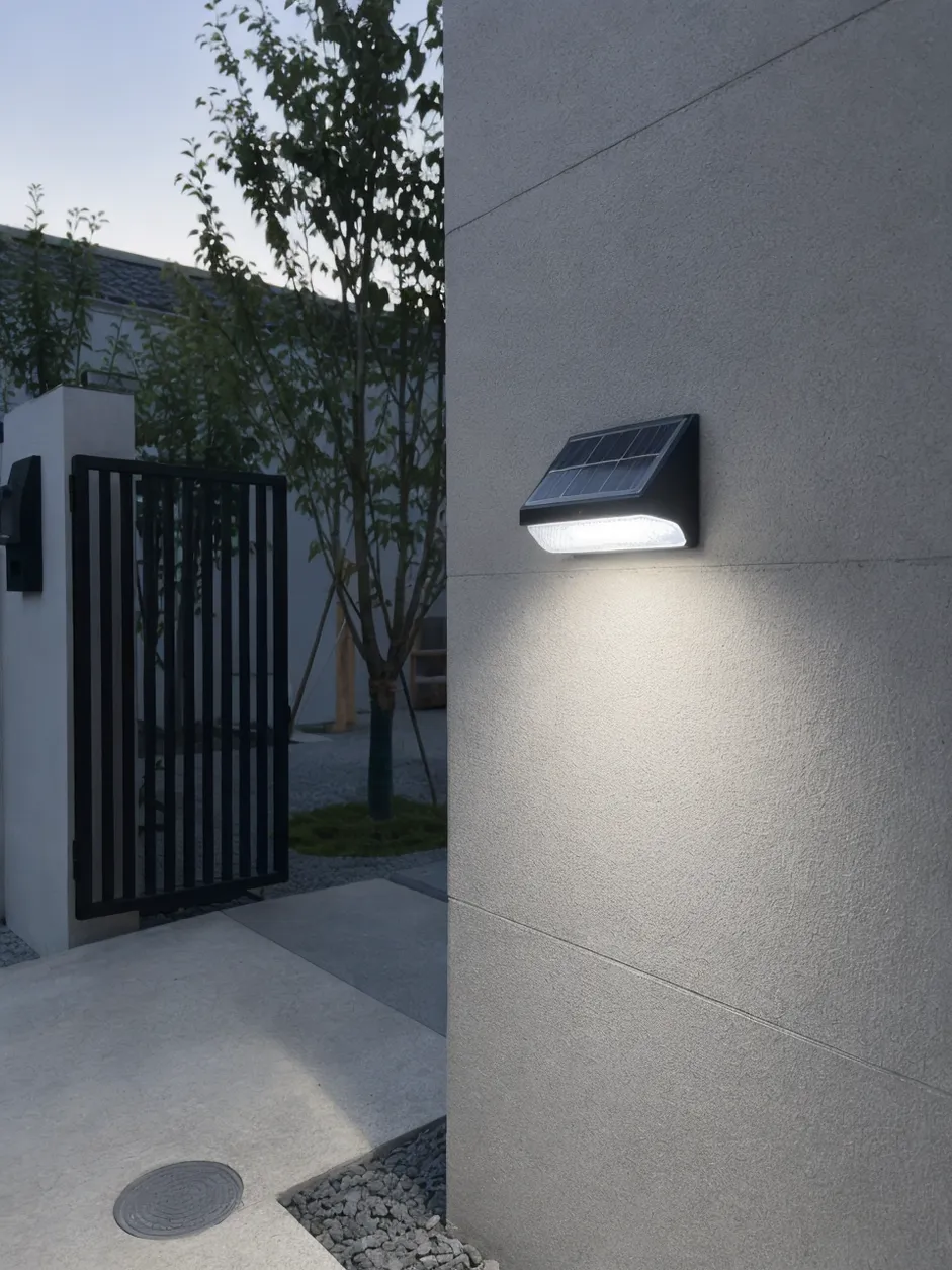 JXSOL integrated solar wall light mounted on exterior wall, illuminating at dusk