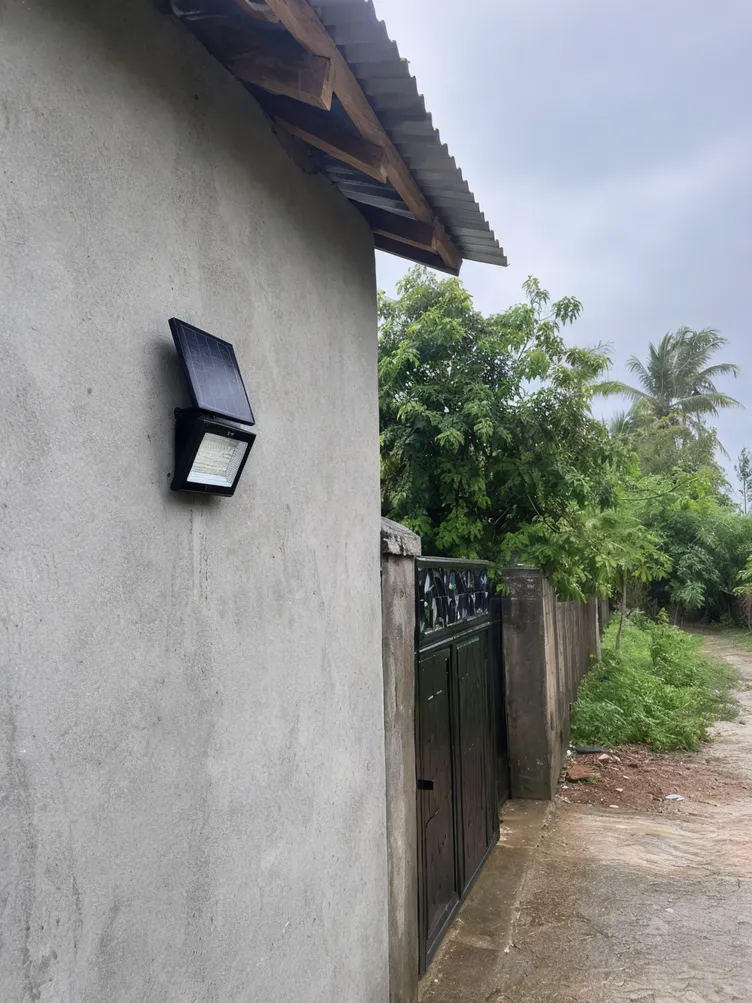 Solar wall light installed on rural building in high-rainfall off-grid region